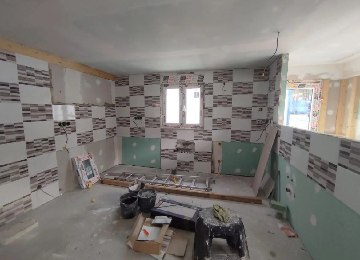Cozinha em obra com revestimento, materiais e escada