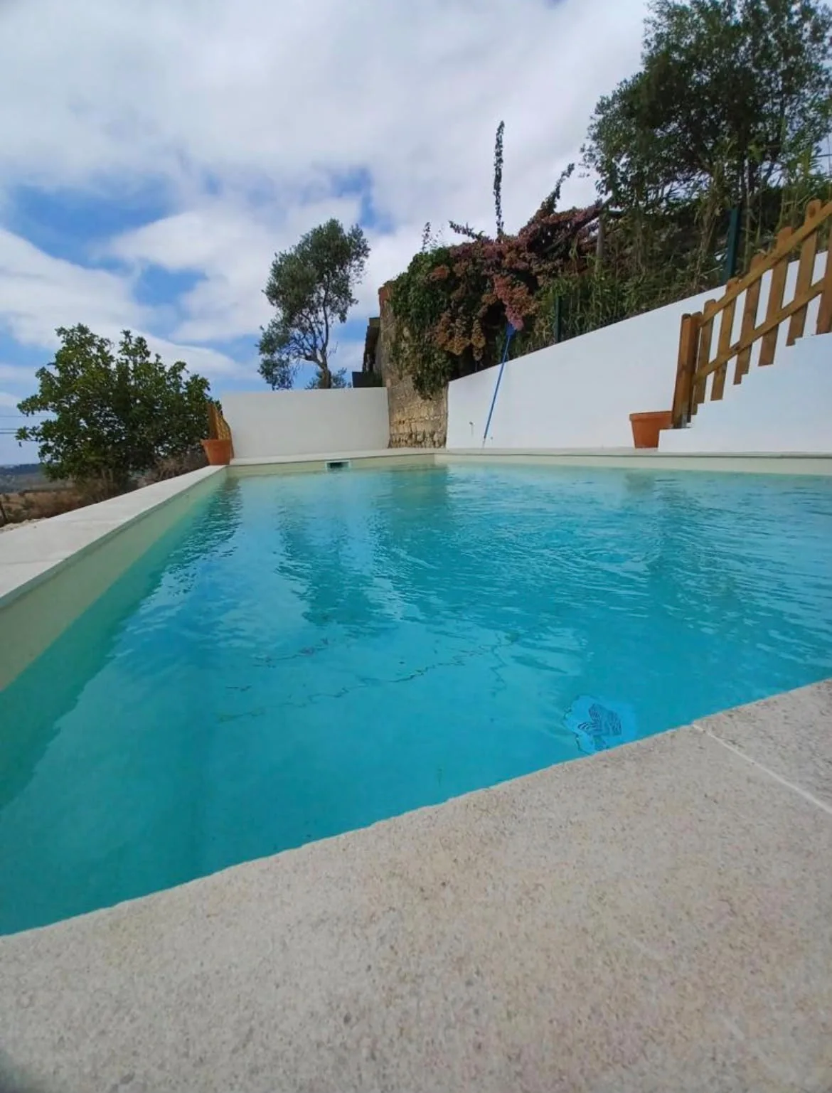 Piscina exterior com água azul e muros claros